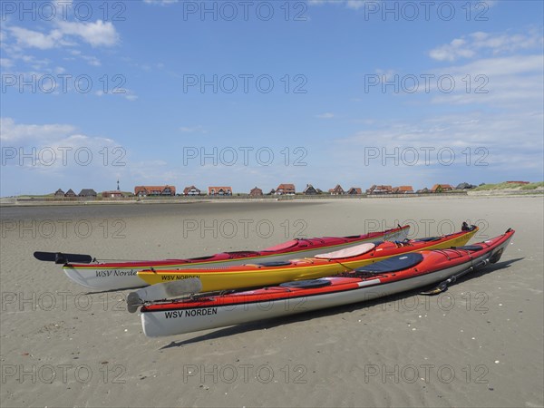 Kayaks on the beach with village in the background, Baltrum Germany