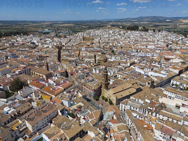 Aerial view of a Spanish old town with many buildings and terracotta-coloured roofs on a sunny day,
