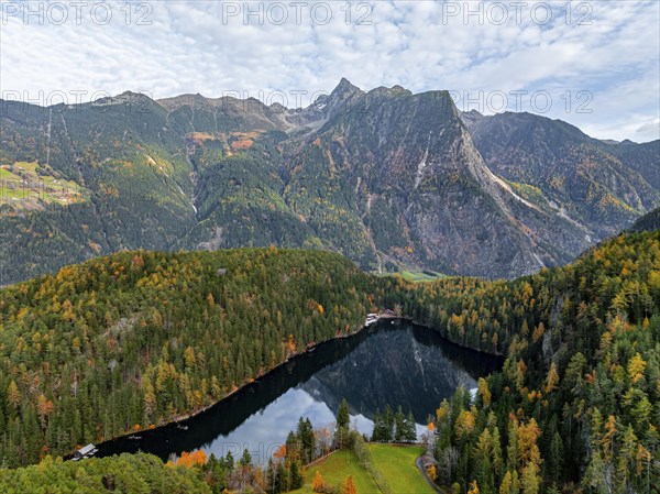 Aerial view, mountain peaks of the Oetztal Alps reflected in Lake Piburger See, in autumn, near