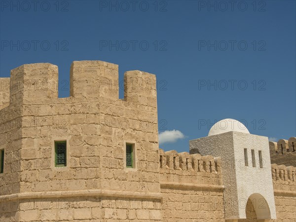 Close-up of a historic fortress with stone walls against a clear blue sky, Tunis in Africa with