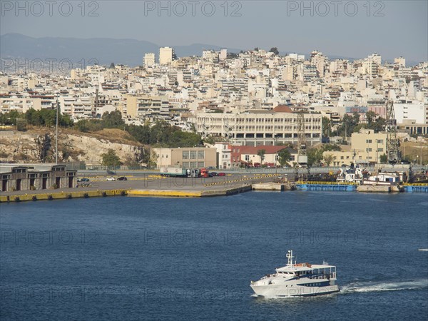 A boat sails in the harbour, in the background numerous buildings of the city, Ancient buildings