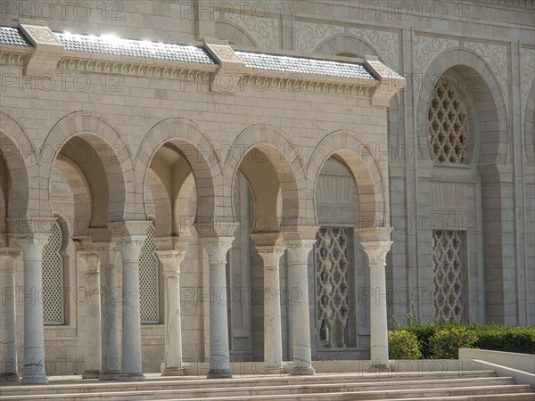 A monumental building with large stone arcades shining in the sunlight, Tunis in Africa with ruins
