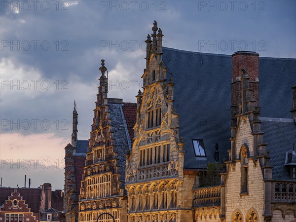 Ornate historic buildings with gabled roofs in Bruges in the light of dusk, historic buildings with