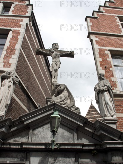 Statue of a crucifixion scene on a historical building under a cloudy sky, Historical Buildings,