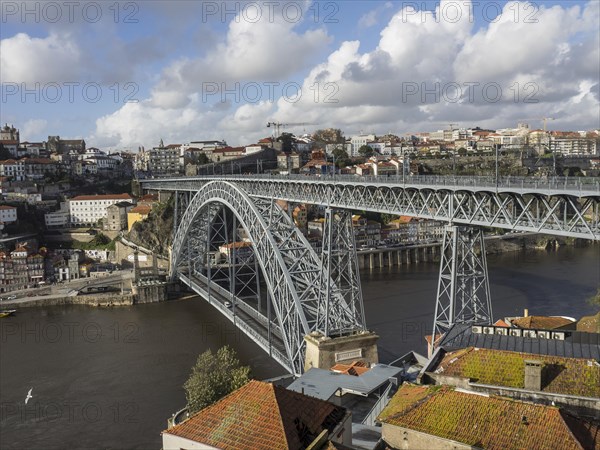 Steel bridge over a river in a historic city in sunny weather with clouds, spring in the old town