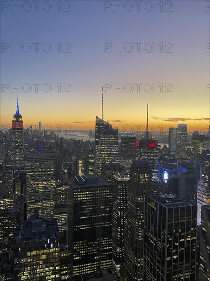 Cityscape at dusk with the Empire State Building and other illuminated skyscrapers, the skyline of
