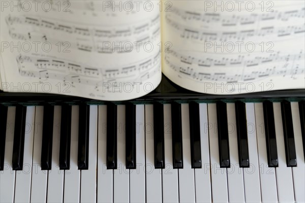 Top view of the keys of a piano with a score on them
