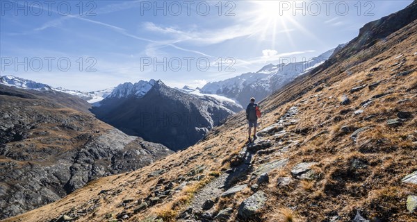 Mountaineers on a hiking trail, hiking trail to Ramolhaus, behind glaciated mountain peaks and