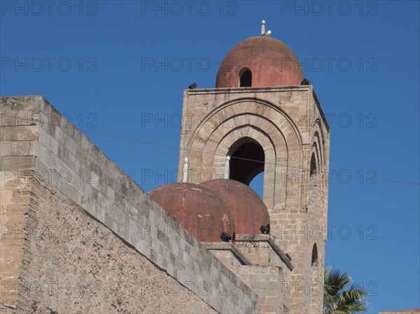 Historic church with red domes and towers against a clear blue sky, palermo in sicily with an