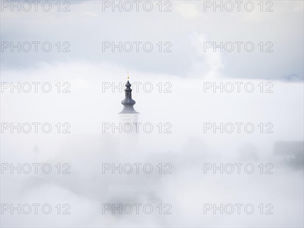 Church tower rises out of the morning mist, Frauenberg pilgrimage church, near Leibnitz, Styria,