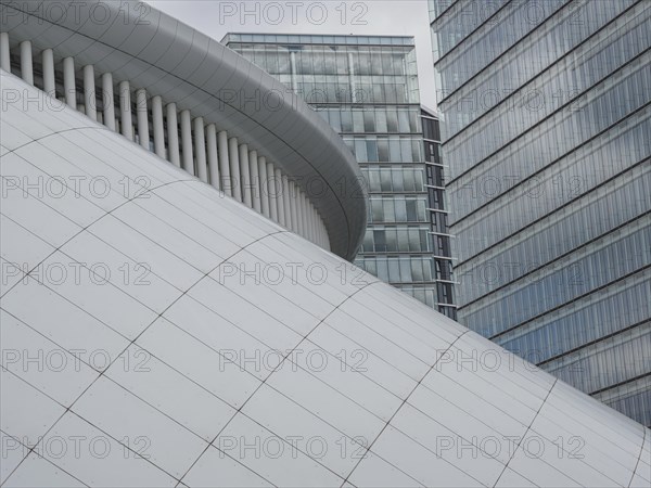 Architecturally modern building with white structure and neighbouring office towers in Luxembourg,