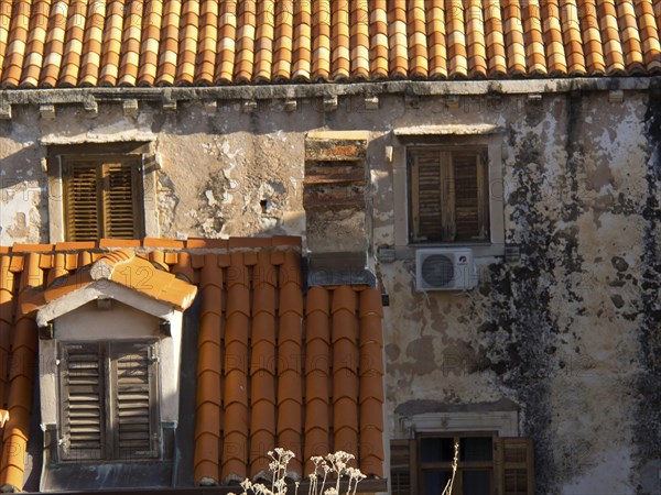 Old buildings with red tiled roofs and closed shutters, partially dilapidated facades, the old town
