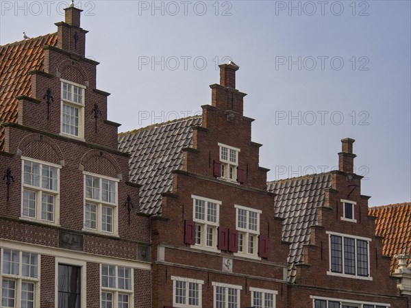 Historic gabled brick houses arranged in rows, with pointed roofs and windows in a traditional
