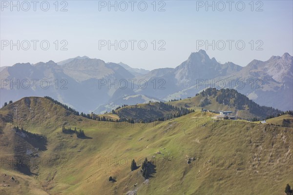 Tranquil mountain landscape with rolling hills and mountain peaks under a clear sky, mountain