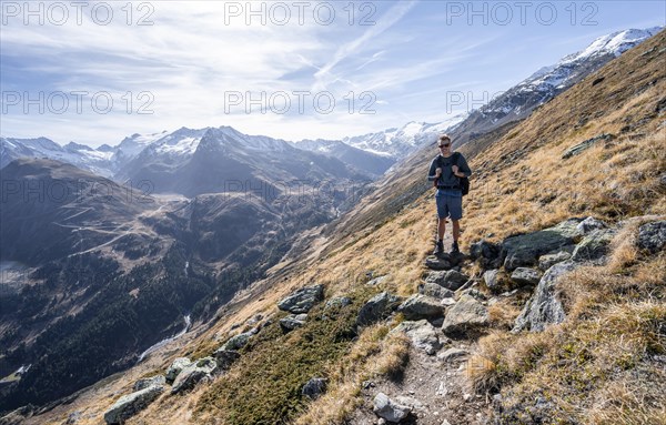 Mountaineers on a hiking trail, Gurgler Seenplatte, glaciated mountain peaks behind, in autumn,
