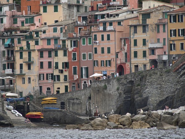 Colourful houses on the rocky coast with harbour and canoes on the water, Bari, Italy, Europe