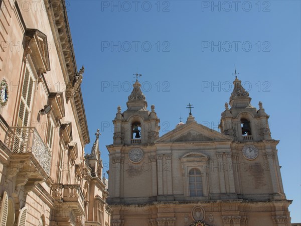 Baroque church with two bell towers in the bright blue sky, the town of mdina on the island of