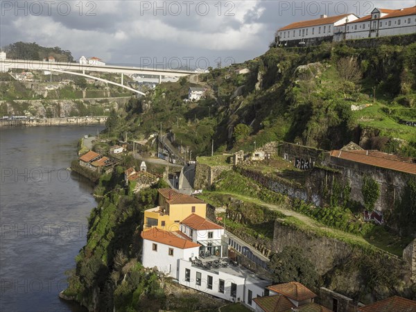 Buildings and green landscapes in a valley next to a river, under a cloudy sky, spring in the old