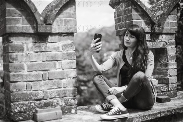 Young hispanic woman in casual clothing focused on conversation with smartphone in a peaceful
