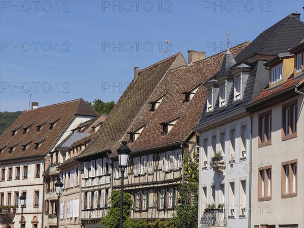 Historic half-timbered houses with red roof tiles and shutters under a blue sky, historic house