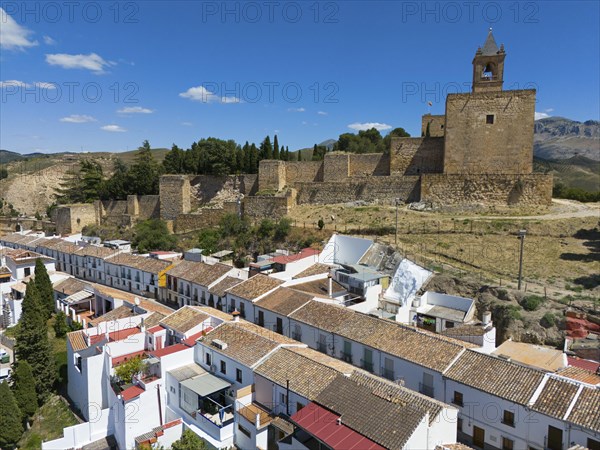 Aerial view of a medieval fortress with neighbouring houses with white walls on a sunny day,