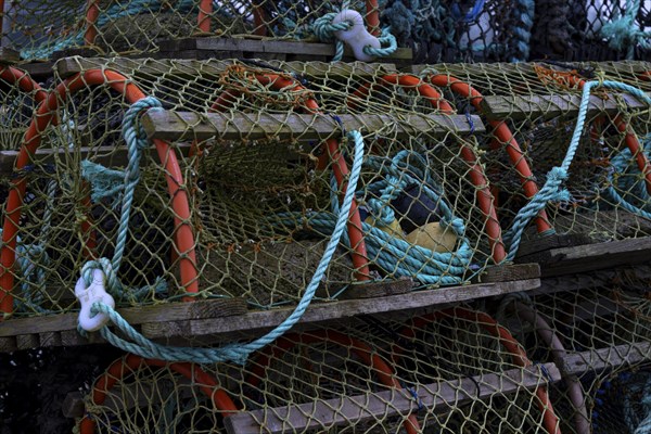 Stacks of lobster traps with fishing nets and ropes, maritime atmosphere