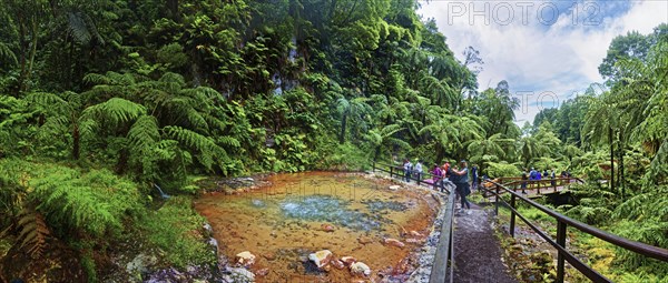 Hiking trail with hot natural thermal spring in Caldeira Velha in a lush green environment with