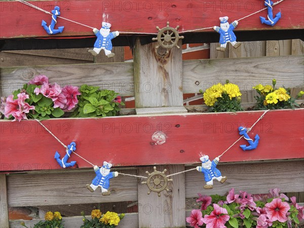 Wooden fence with floral decorations and decorative bear figures, Baltrum Germany