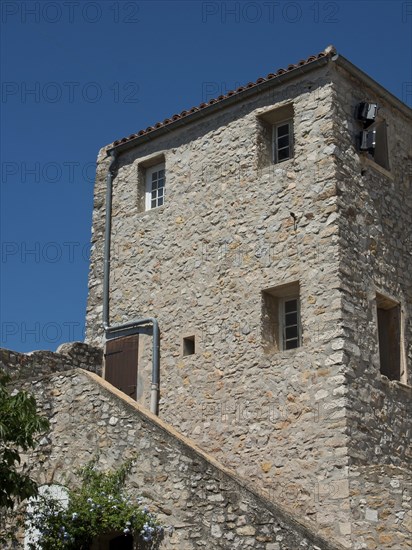 A three-storey stone house with small windows under a clear blue sky, Provence, le Castellet,