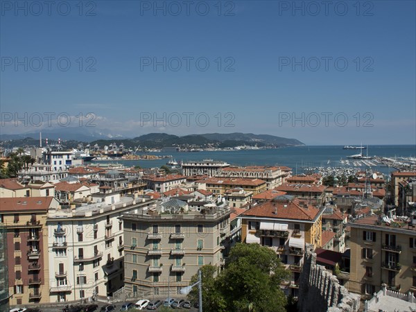 Panoramic view of a coastal town with rooftops, harbour and boats under a blue sky, Bari, Italy,