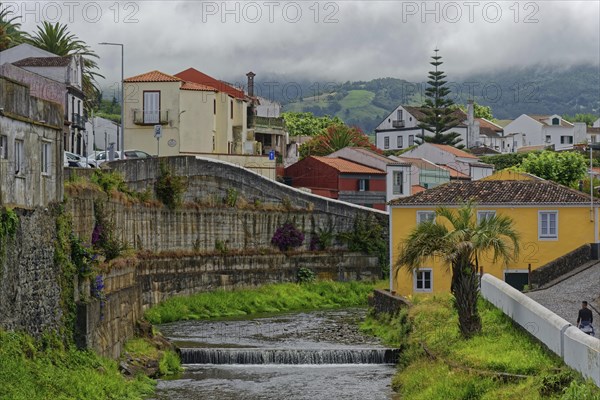 An idyllic village with colourfully painted houses, through which the Ribeira Grande river flows,