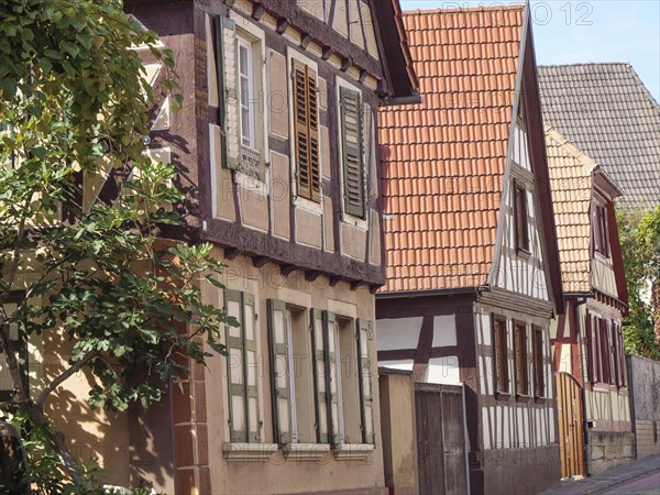Row of traditional half-timbered houses along a narrow alley on a sunny day, historic half-timbered
