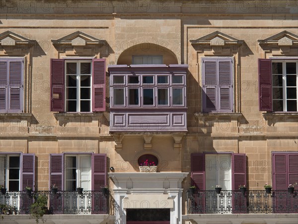 Building facade with purple shutters and small balconies, the town of mdina on the island of malta