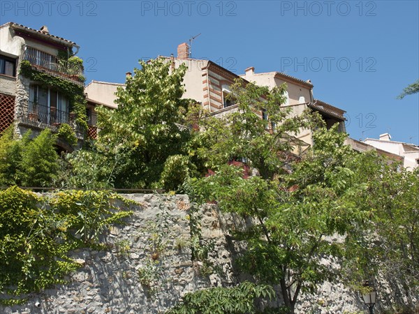Several Mediterranean houses, surrounded by lush vegetation, under a clear blue sky, Provence, le