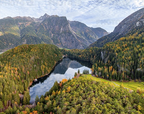 Aerial view, mountain peaks of the Oetztal Alps reflected in Lake Piburger See, in autumn, near
