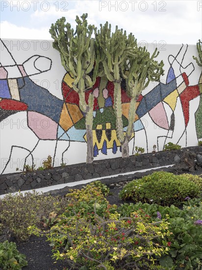 Colourful mosaic artwork on a wall with a cactus in the foreground, Lanzarote, Spain, Europe