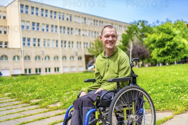 Man with disability sitting in an electric wheelchair in the university campus