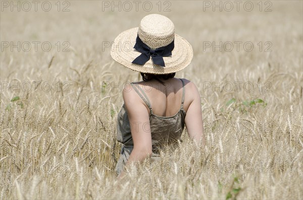 Woman with a Straw Hat Standing in a Wheat Field in a Sunny Summer Day in Ticino, Switzerland,