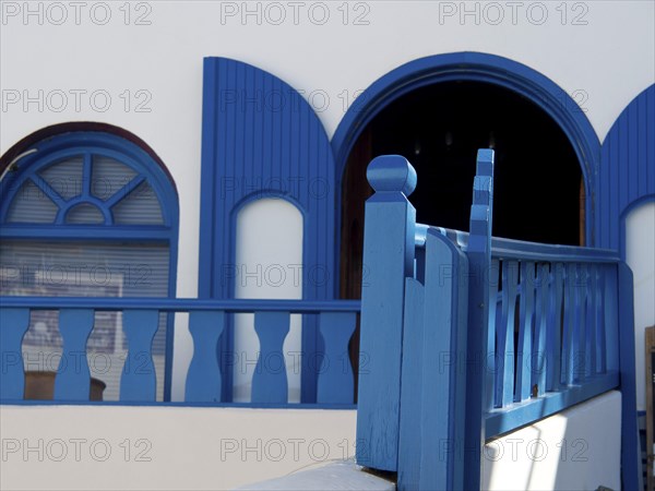 A blue and white building with traditional Greek design elements, The volcanic island of Santorini