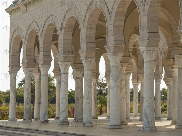 The exterior of a building with marble columns and arches in bright light, Tunis in Africa with