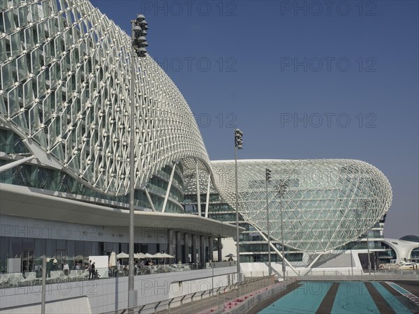 Building with modern grid structure, large windows and racetrack under blue sky, Abu Dhabi, United