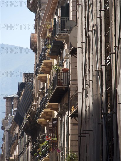 View of narrow streets with balconies and historic buildings in a mediterranean old town, palermo