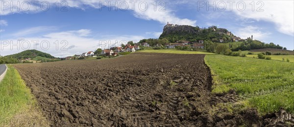 Clods of earth in farmland, Riegersburg Castle in the background, panoramic view, near Riegersburg,