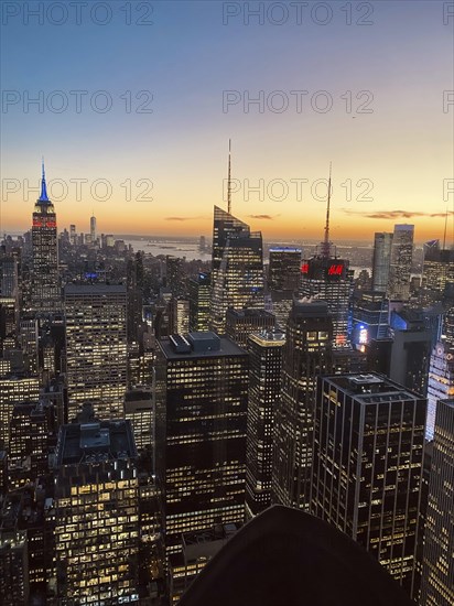 Modern cityscape at sunset with glowing skyscrapers and an atmospheric sky, the skyline of new york