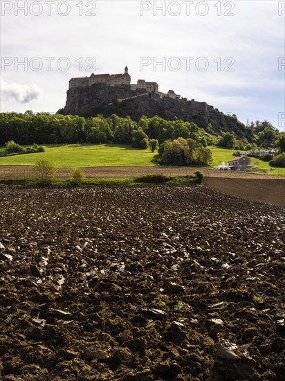 Clods of earth in farmland, Riegersburg Castle in the background, near Riegersburg, Styria,