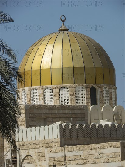 A golden dome on a mosque building with a clear blue sky in the background, Abu Dhabi, United Arab