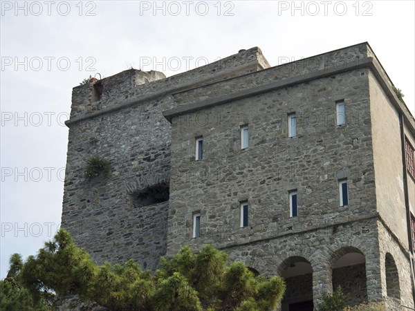 Old, historic building with stone walls and castle tower, surrounded by vegetation, Bari, Italy,