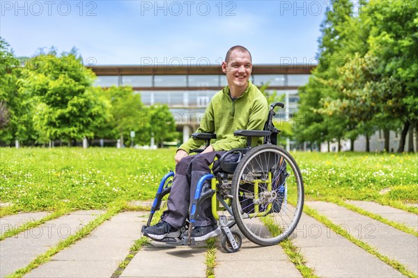 Full length portrait of a disabled man with cerebral palsy in the university campus