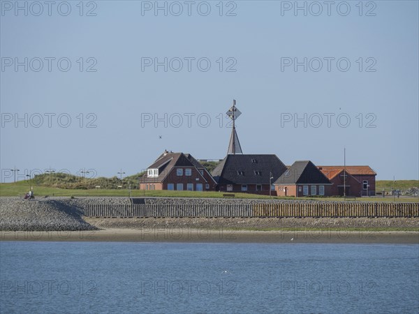 Quiet coastal scene with houses on the shore under a clear sky, Baltrum Germany