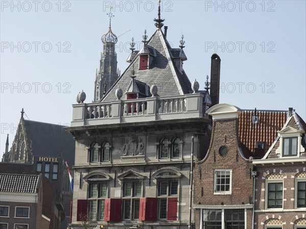 Historic buildings and a church with a hotel in the foreground under a clear blue sky, Haarlem,